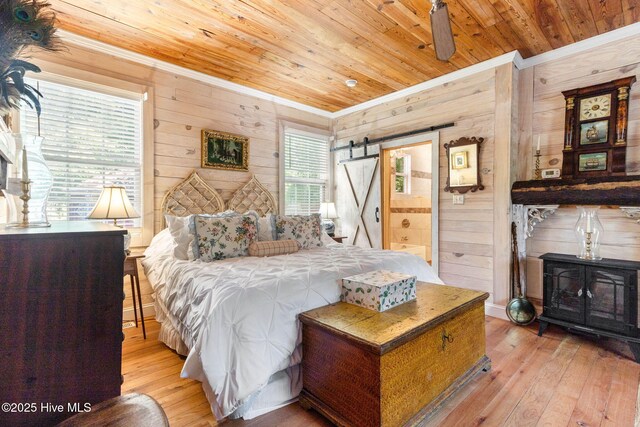 121 Dolphin Ln, Sneads Ferry, NC 28460 - bedroom featuring crown molding, wooden ceiling, wood walls, hardwood / wood-style flooring, and a barn door