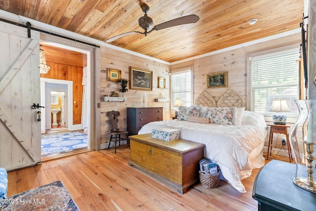 121 Dolphin Ln, Sneads Ferry, NC 28460 - bedroom with wood ceiling, ornamental molding, wood walls, a barn door, and light wood-style flooring