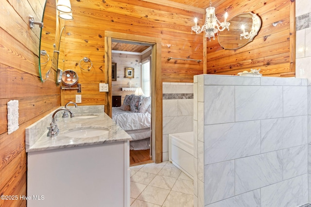 121 Dolphin Ln, Sneads Ferry, NC 28460 - ensuite bathroom featuring wood walls, double vanity, a chandelier, tile patterned floors, and a bath