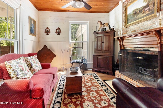 121 Dolphin Ln, Sneads Ferry, NC 28460 - living area featuring a brick fireplace, wooden ceiling, ceiling fan, wood finished floors, and wooden walls