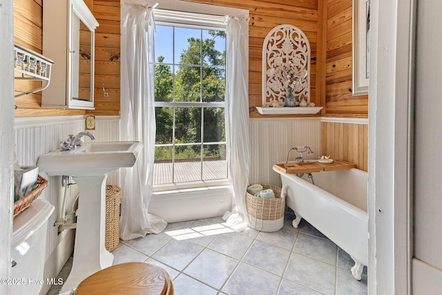 121 Dolphin Ln, Sneads Ferry, NC 28460 - bathroom with wooden walls, a freestanding bath, and tile patterned floors