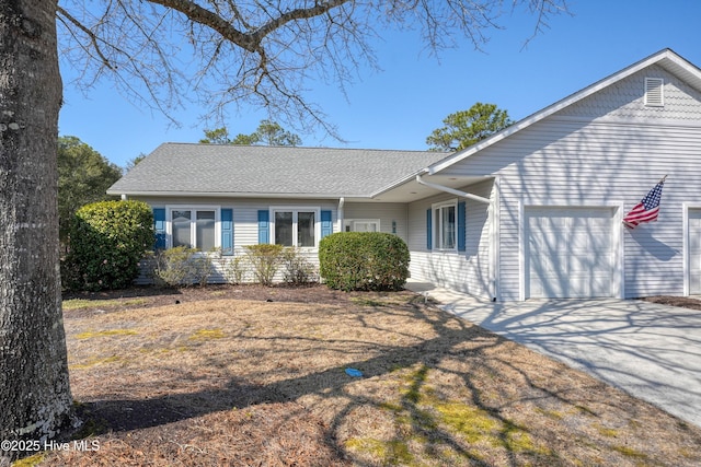 single story home featuring concrete driveway, roof with shingles, and an attached garage