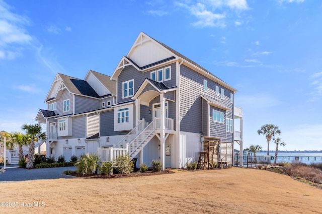 view of front facade featuring stairs, a water view, and board and batten siding