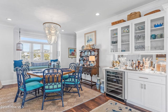 dining area with dark wood-style floors, bar, ornamental molding, recessed lighting, and wine cooler