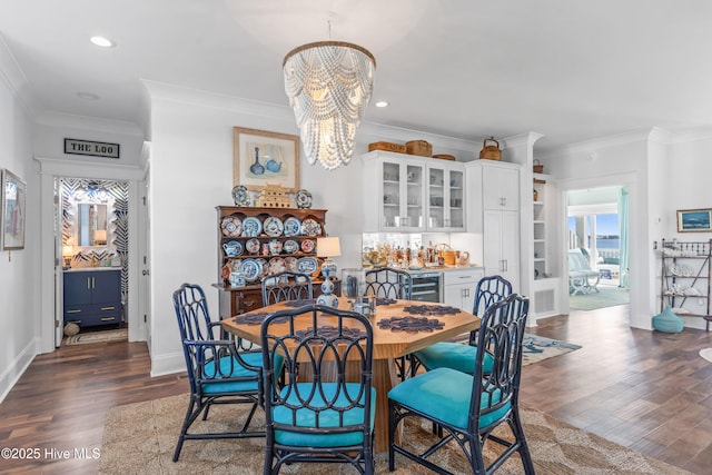 dining area featuring dark wood-type flooring, beverage cooler, a notable chandelier, and crown molding