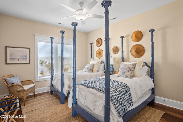 bedroom featuring baseboards, visible vents, and wood finished floors