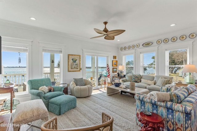 living room featuring ceiling fan, recessed lighting, a water view, and crown molding