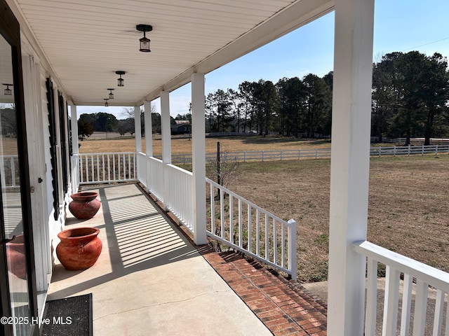 view of patio / terrace with fence and a rural view