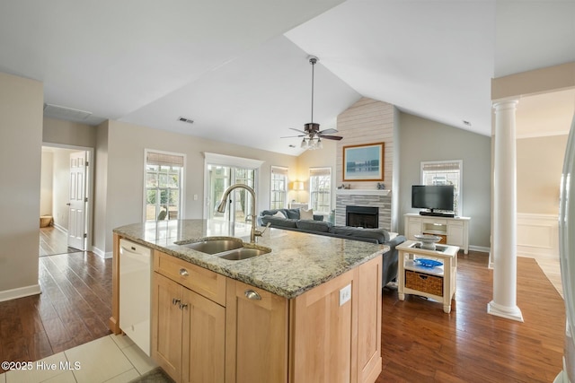 kitchen with dark wood-type flooring, white dishwasher, ornate columns, and a sink