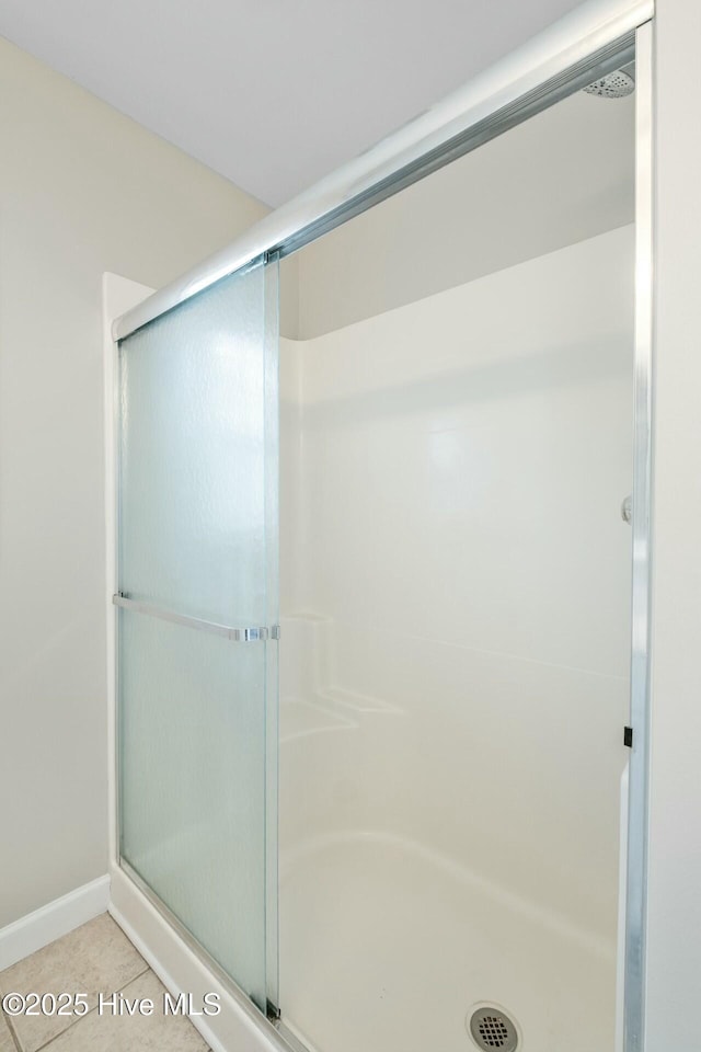 full bath with a shower stall and tile patterned floors