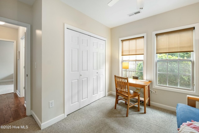 carpeted office space featuring baseboards and visible vents