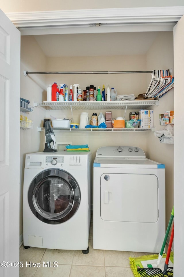 clothes washing area with washer and clothes dryer, laundry area, and light tile patterned flooring