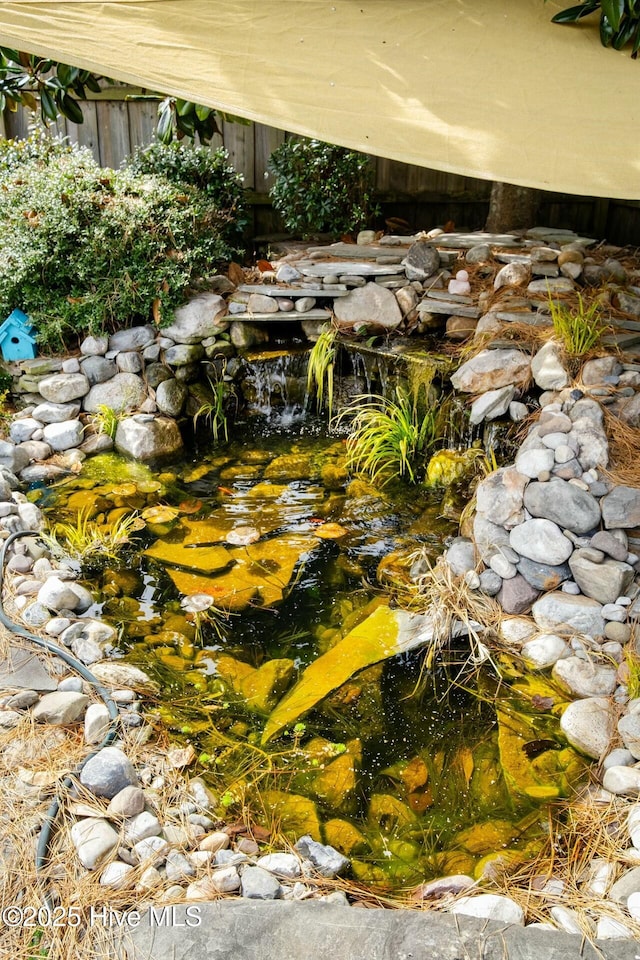 exterior details with a garden pond and fence