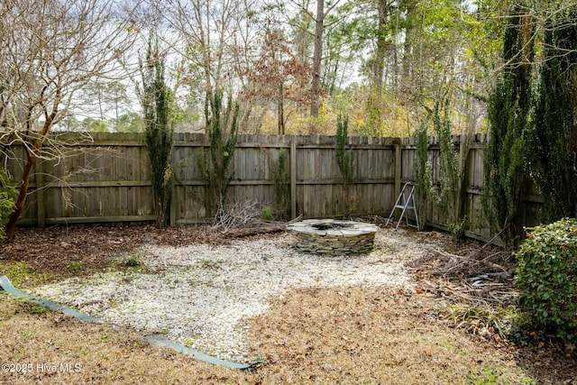 view of yard featuring a fire pit and a fenced backyard