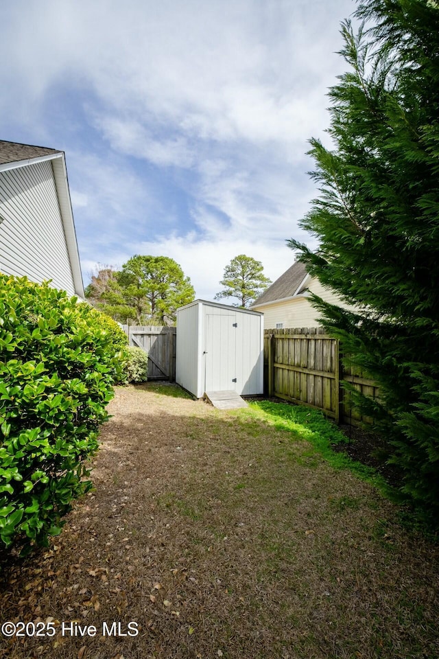 view of yard featuring an outdoor structure, a storage shed, and a fenced backyard