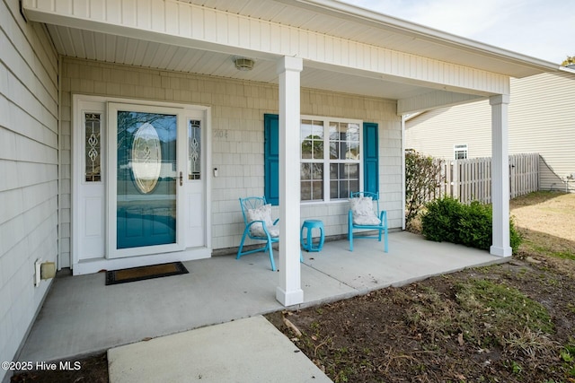 property entrance with a porch and fence