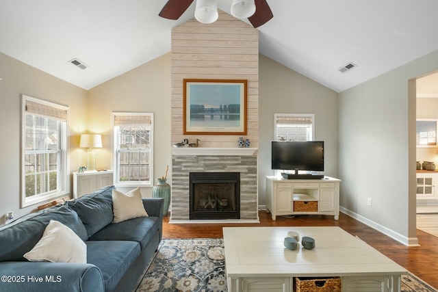 living area with visible vents, lofted ceiling, wood finished floors, and a fireplace