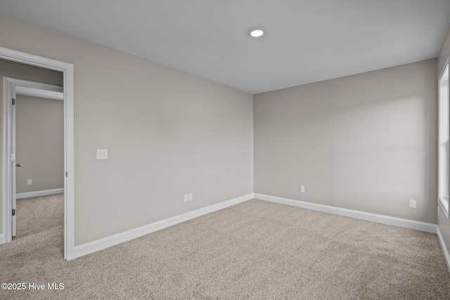 carpeted spare room with baseboards