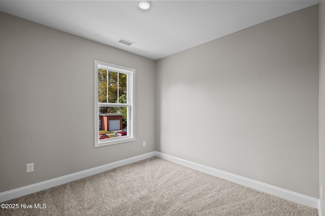 carpeted empty room featuring baseboards and visible vents