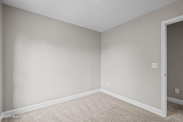 carpeted empty room featuring baseboards