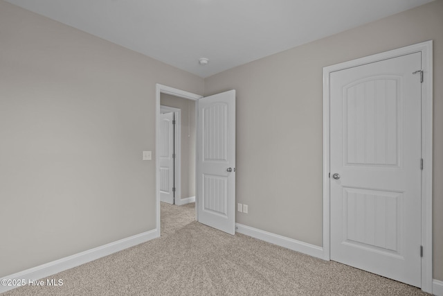 unfurnished bedroom featuring carpet flooring and baseboards