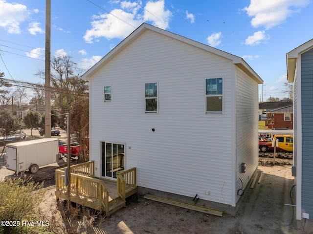 rear view of house featuring a wooden deck