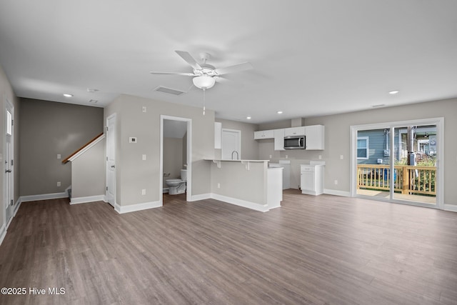 unfurnished living room featuring baseboards, recessed lighting, a ceiling fan, and wood finished floors