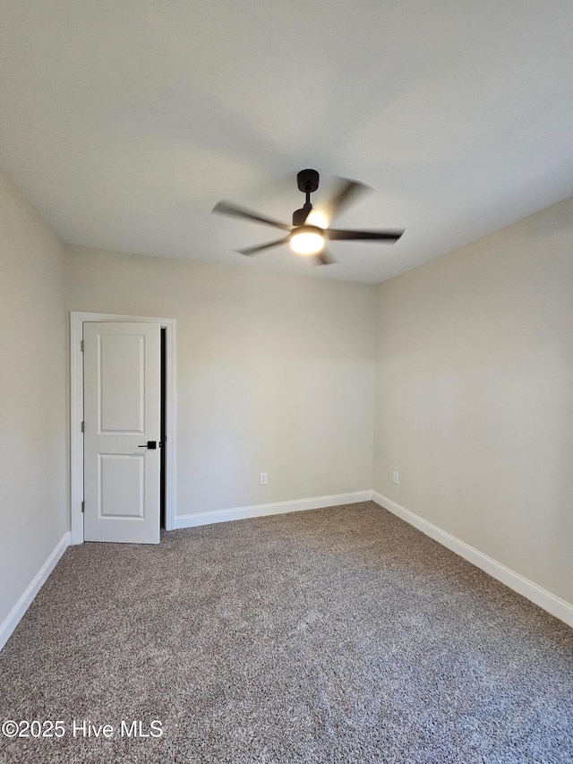 spare room with carpet floors, ceiling fan, and baseboards