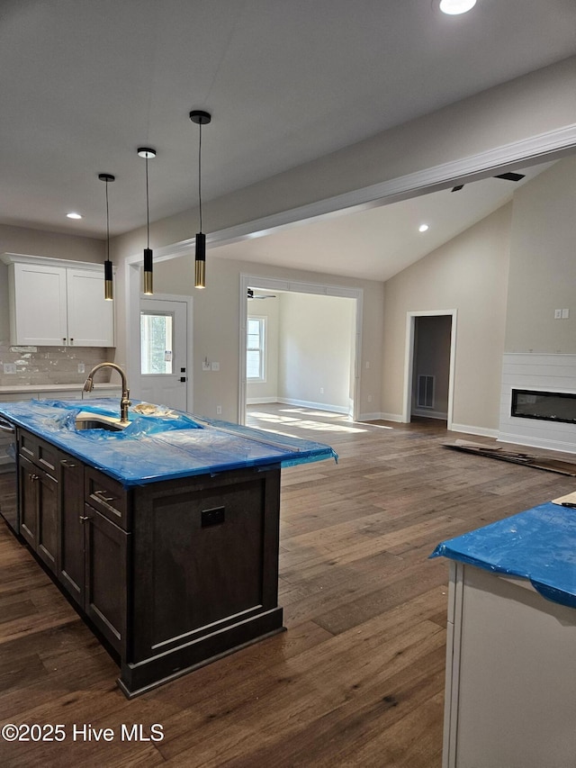 kitchen with dark wood-style floors, open floor plan, a sink, and dishwasher