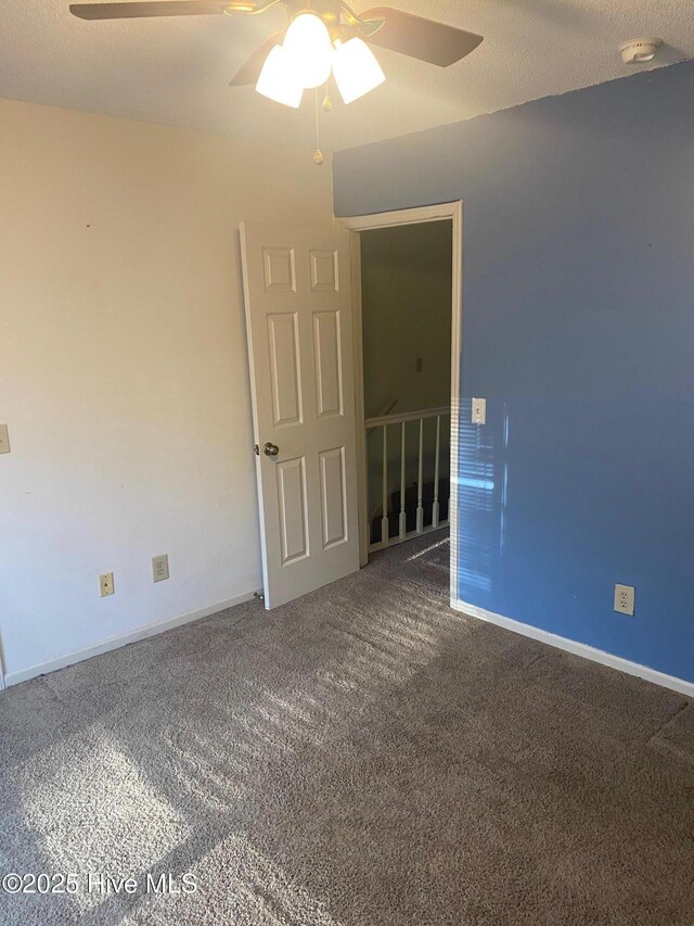 unfurnished room with carpet floors, ceiling fan, and baseboards