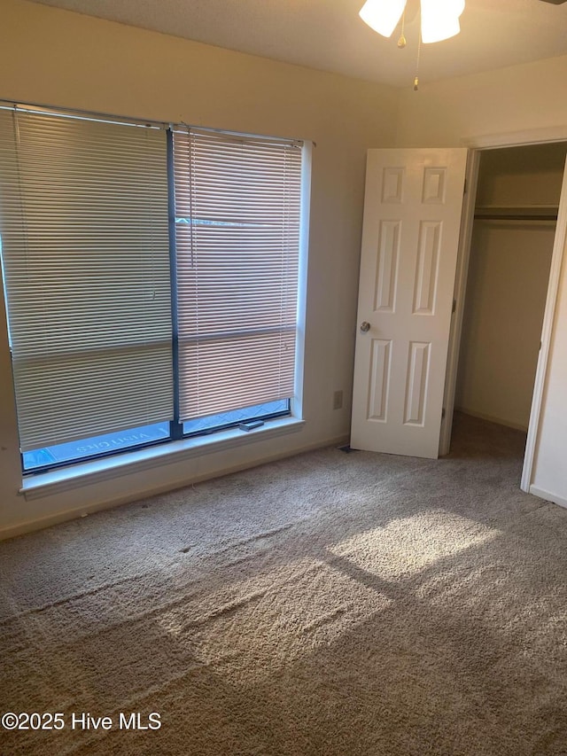 unfurnished bedroom with a closet, carpet flooring, and baseboards