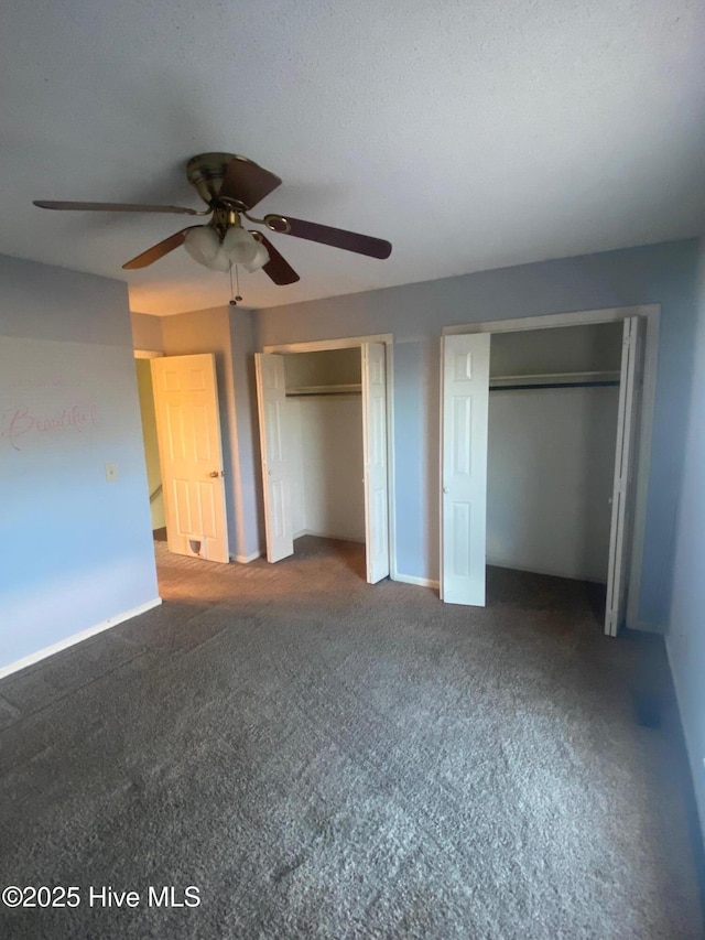 unfurnished bedroom featuring baseboards, carpet, a ceiling fan, and multiple closets