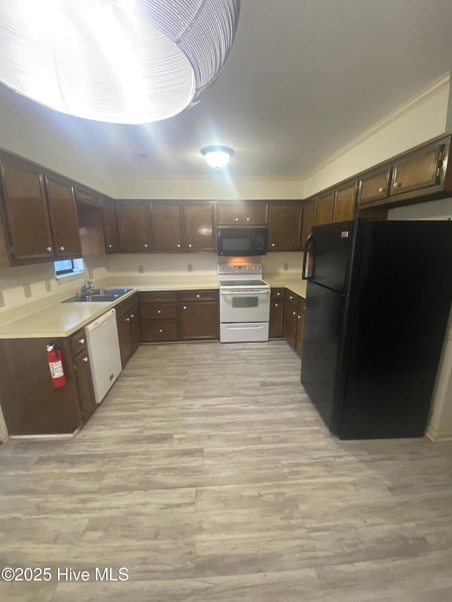 kitchen with black appliances, dark brown cabinets, light wood finished floors, and light countertops