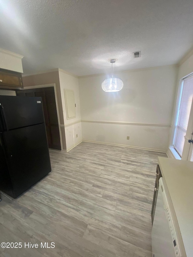 interior space with visible vents, baseboards, light wood-style flooring, and a textured ceiling