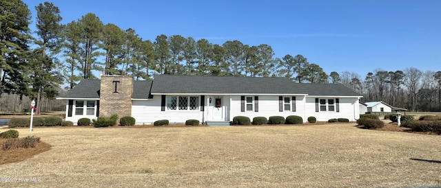 ranch-style house featuring a front yard and a chimney