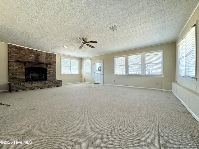 unfurnished living room featuring a brick fireplace, light carpet, ceiling fan, and baseboards