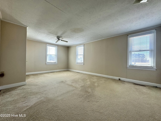 empty room with carpet floors, ornamental molding, and baseboards