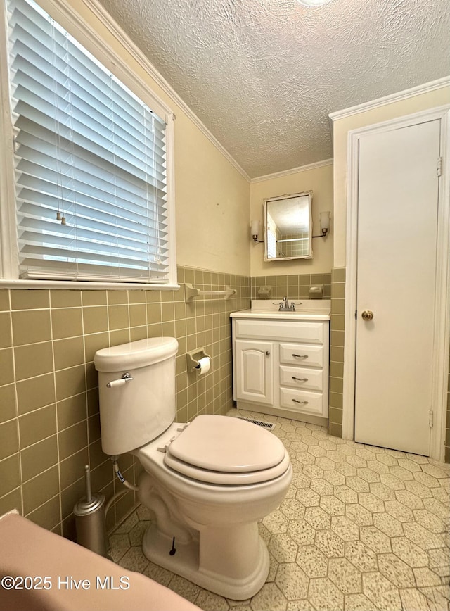 bathroom with toilet, ornamental molding, a textured ceiling, and vanity