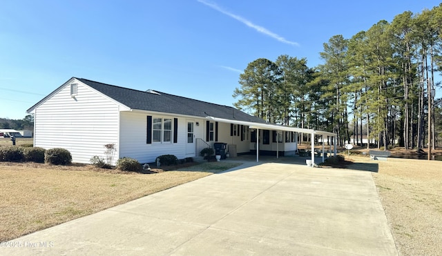 ranch-style house with an attached carport, concrete driveway, and a front yard