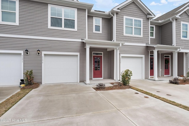 multi unit property featuring driveway and a garage