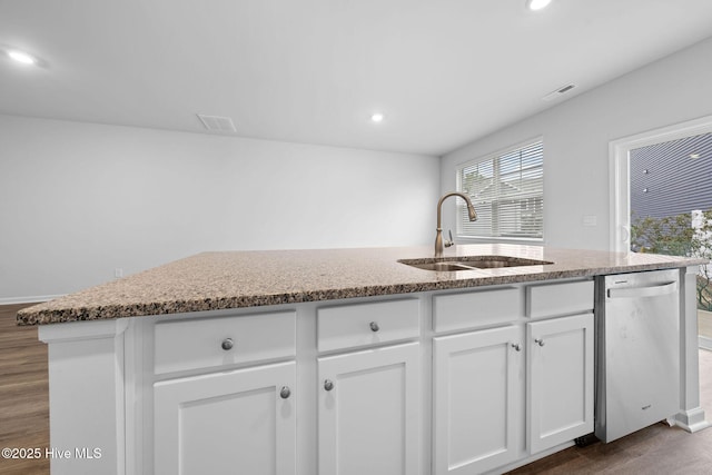 kitchen with visible vents, white cabinets, dishwasher, an island with sink, and a sink