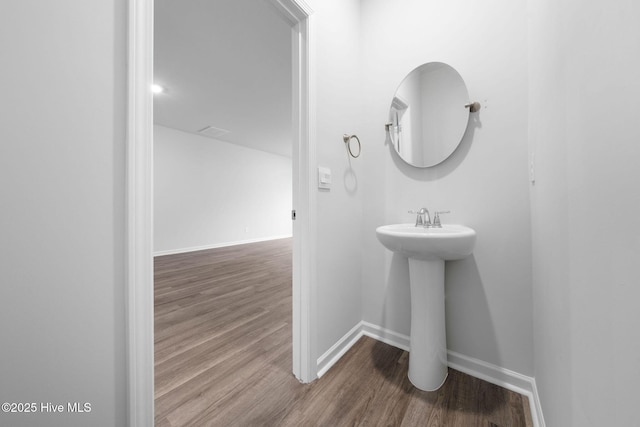 bathroom featuring a sink, baseboards, and wood finished floors