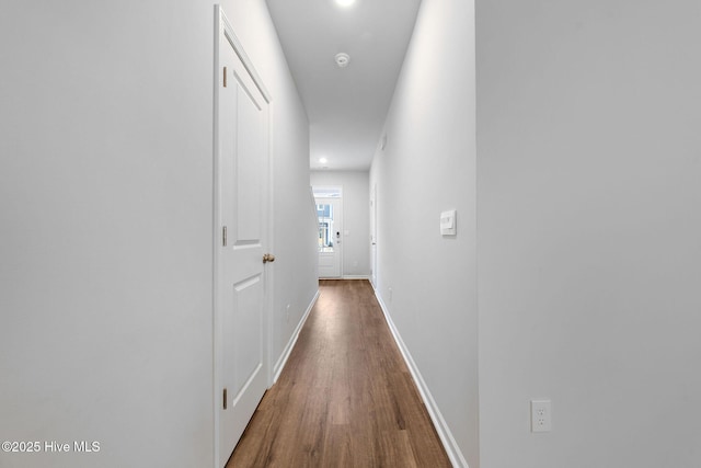 hallway with baseboards and wood finished floors