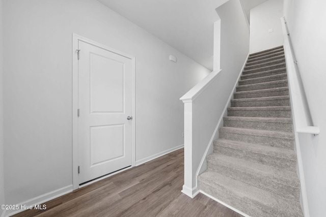 stairway featuring baseboards and wood finished floors