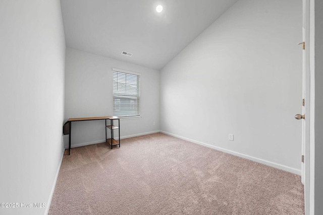 carpeted empty room with visible vents, baseboards, and vaulted ceiling