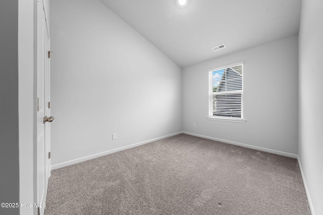 carpeted empty room with lofted ceiling, visible vents, and baseboards