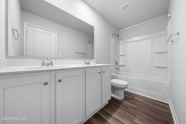 full bath with visible vents, a sink, shower / bathtub combination, and wood finished floors