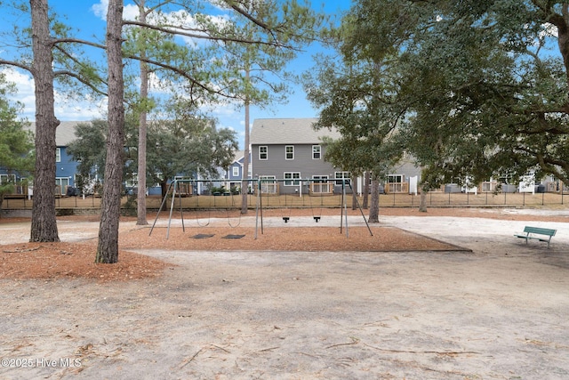 view of yard featuring playground community and fence