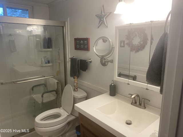 bathroom featuring toilet, vanity, and a shower with shower door