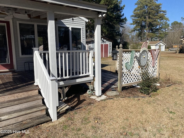 wooden terrace featuring a yard and a storage shed